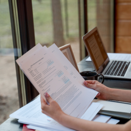 Person reviewing documents and notes at a desk, representing the step-by-step process of preparing and reviewing information before a legal strategy or record relief consultation