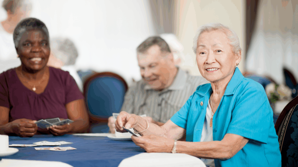 Diverse group of smiling seniors gathered around a table in a friendly social setting
