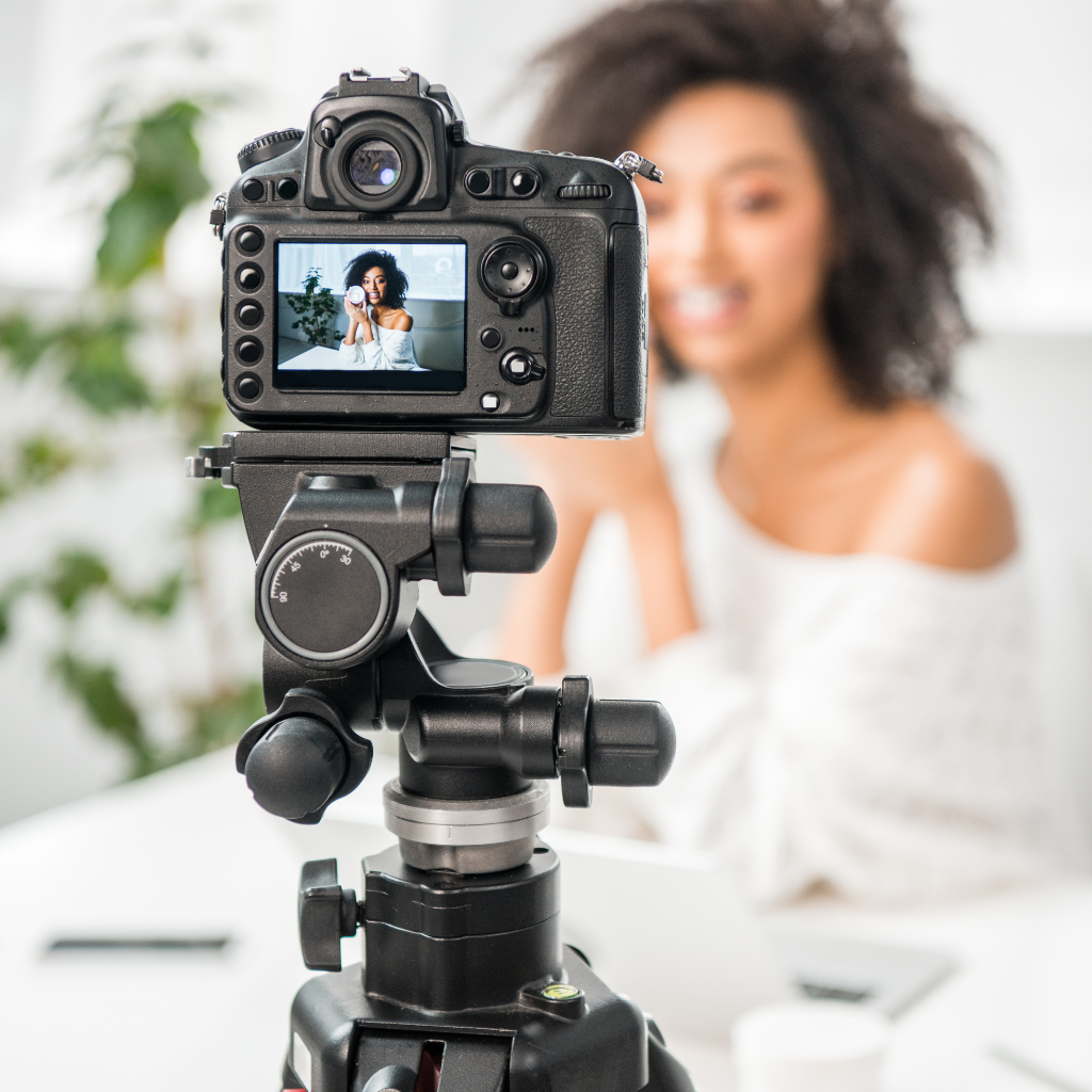 Camera focused on Black female content creator filming herself indoors