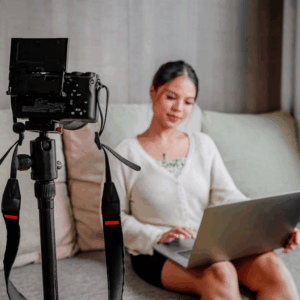 Latina content creator filming herself while working on a laptop — Know Your Worth™ Creator Checklist for pricing, contracts, and brand deal negotiation.