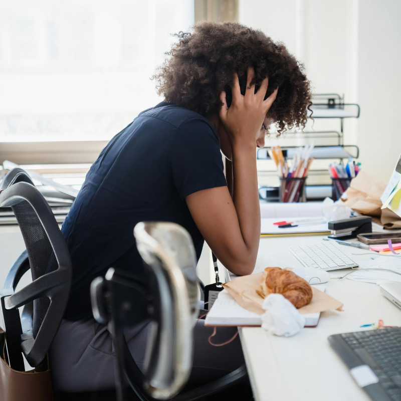 Overwhelmed creator at desk with head in hands, stressed about managing brand deals and finances.